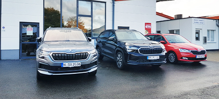 Drei Autos vor einem Gebäude